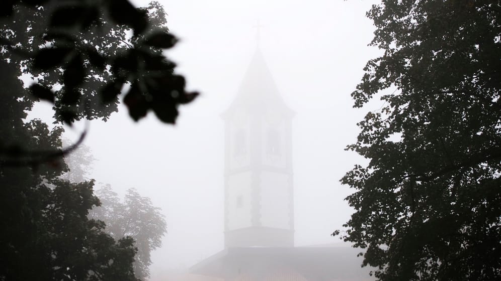 Der Nebel lässt nur die Umrisse des Kirchturms im Hintergrund erkennen. Nebel in Cakovec, Kroatien