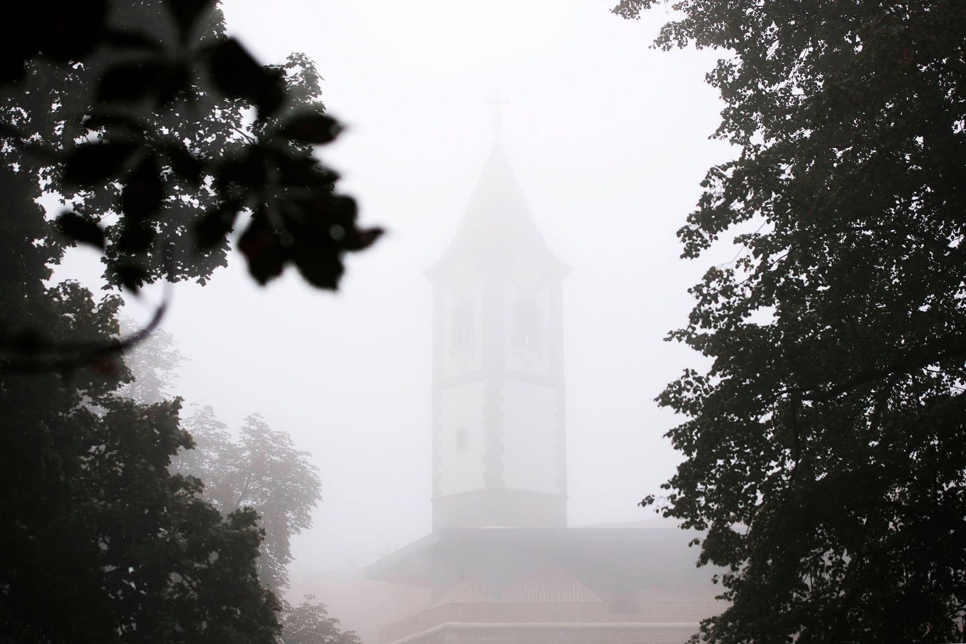 Der Nebel lässt nur die Umrisse des Kirchturms im Hintergrund erkennen. Nebel in Cakovec, Kroatien