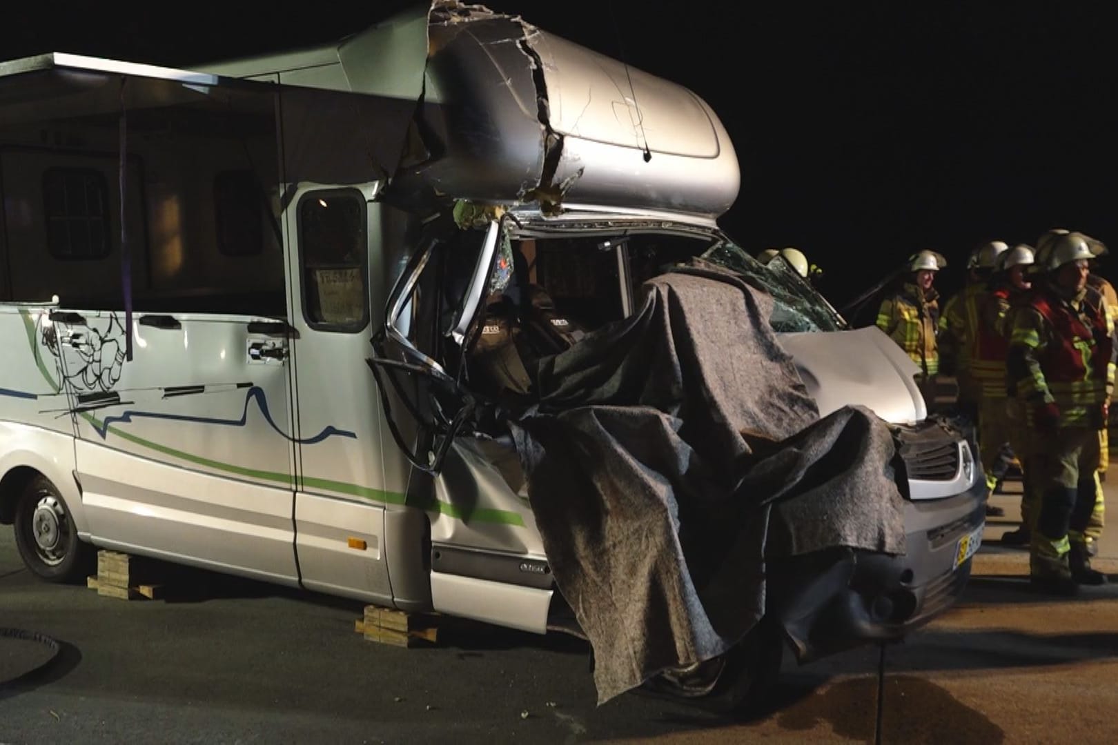 Zerstörtes Wohnmobil: Einsatzkräfte haben den Fahrerbereich mit Decken behangen.