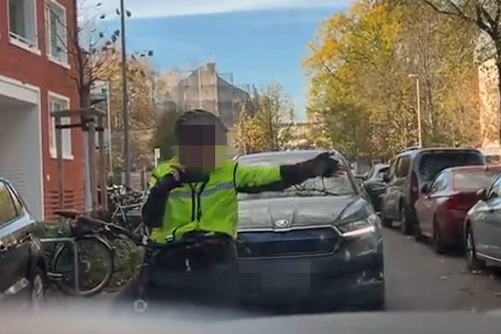 Frau auf Fahrrad hält den Verkehr in enger Straße auf