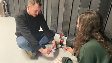 Jay und Kerri vertreiben sich die – wahrscheinlich längere – Wartezeit, um Karten zu spielen.