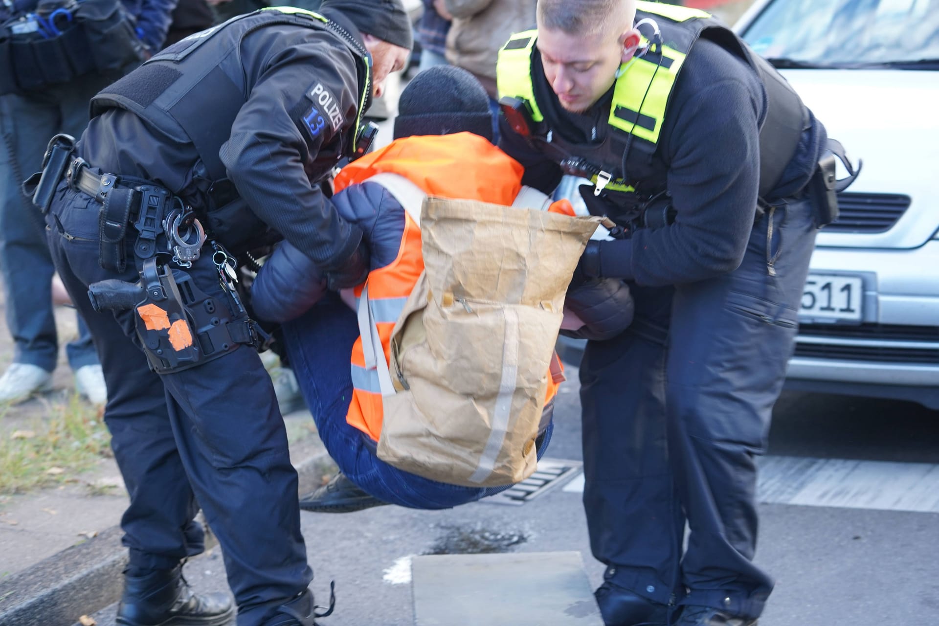 Berlin-Steglitz, Mitte Oktober: Polizisten tragen ein Mitglied der "Letzten Generation" von der Fahrbahn der A103.