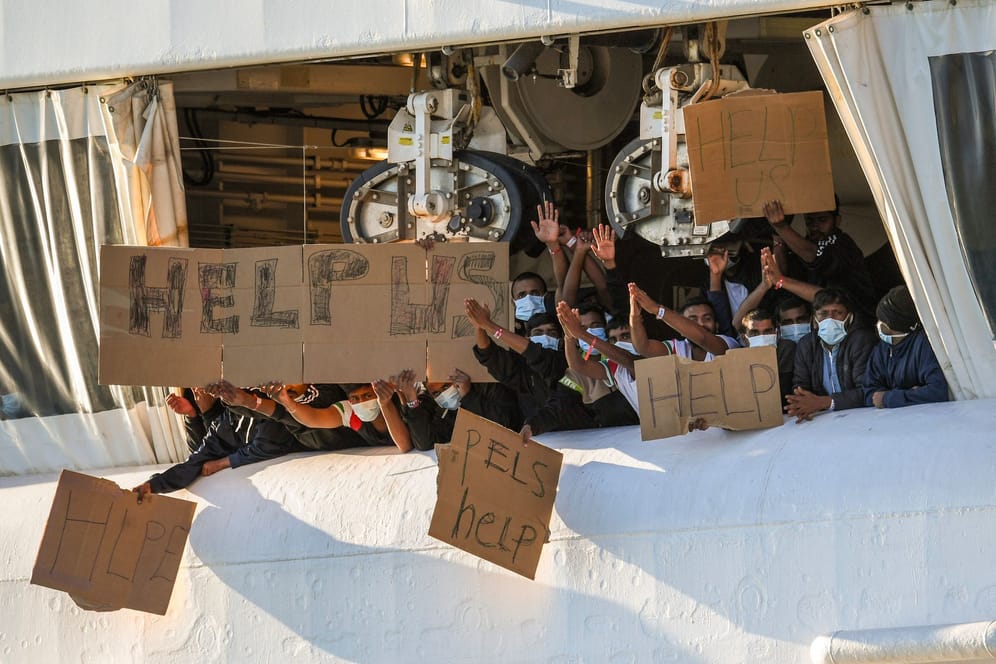 Migranten halten Transparente mit der Bitte um Hilfe an Deck des Schiffes "Geo Barents": Das Schiff durfte am Sonntag einige Menschen von Bord lassen.