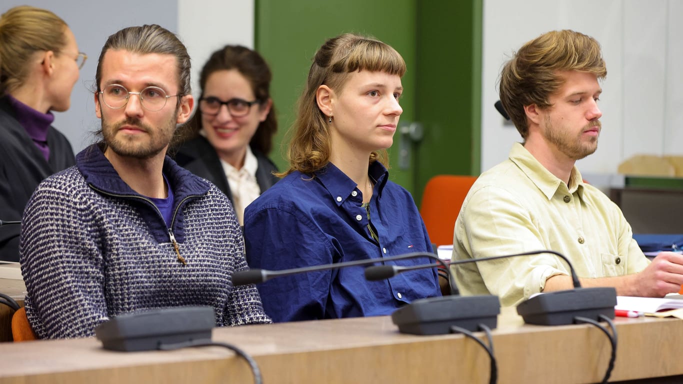 Lars Werner, Charlotte Schwarzer und Joel Schmitt (von links) vor ihrem Prozess wegen Nötigung am Münchner Amtsgericht. Die Klimaaktivisten hatten sich Anfang November am Stachus festgeklebt.