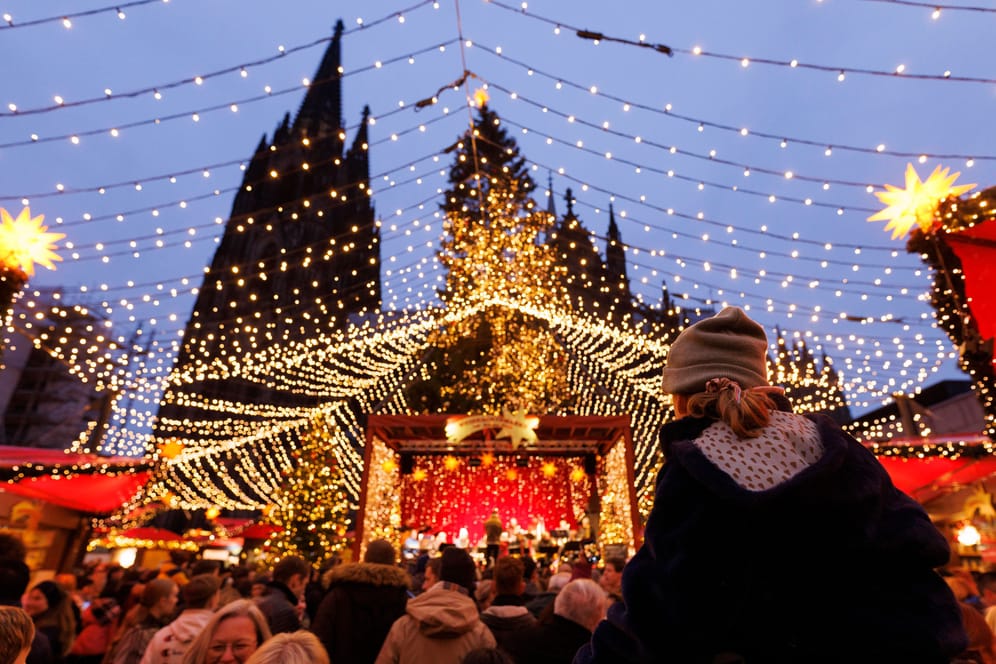 Lichter und Weihnachtsbuden auf einem Weihnachtsmarkt am Dom in Köln. Deutschlands beliebtester Weihnachtsmarkt befindet sich direkt vor der prachtvollen Kulisse des Kölner Doms. Vier Millionen Menschen genießen hier jährlich die vielen lokalen Spezialitäten und die einzigartige Atmosphäre. Themenbild, Symbolbild Köln, 20.11.2022 NRW Deutschland