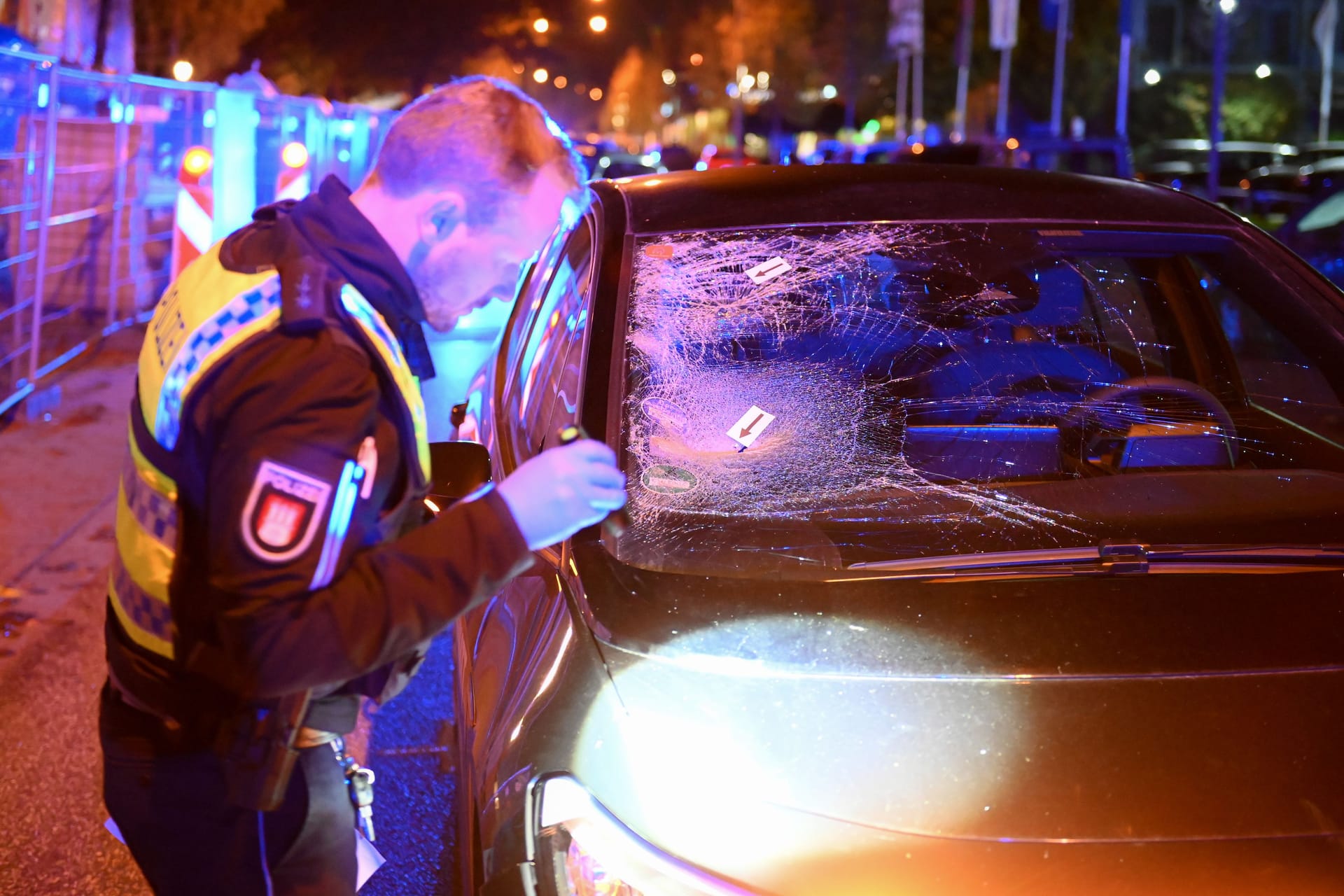 Ein Polizist steht neben dem Unfallwagen: Der Mann trat wohl unvermittelt auf die Straße.