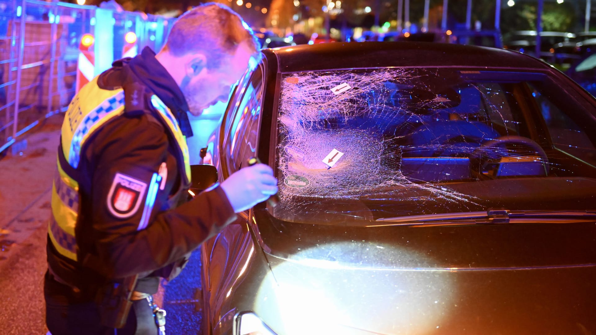 Ein Polizist steht neben dem Unfallwagen: Der Mann trat wohl unvermittelt auf die Straße.