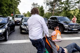 Straßenblockade der letzten Generation Autofahrer versuchen die Klimaaktivisten von der Straße zu ziehen. Am 16.05. Bloc