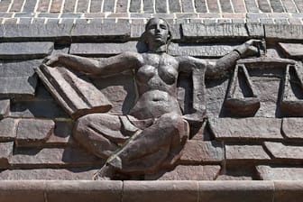 Justitia über dem Eingang eines Landgerichts (Symbolfoto): Die Frau muss sich wegen Körperverletzung mit Todesfolge durch Unterlassen verantworten.