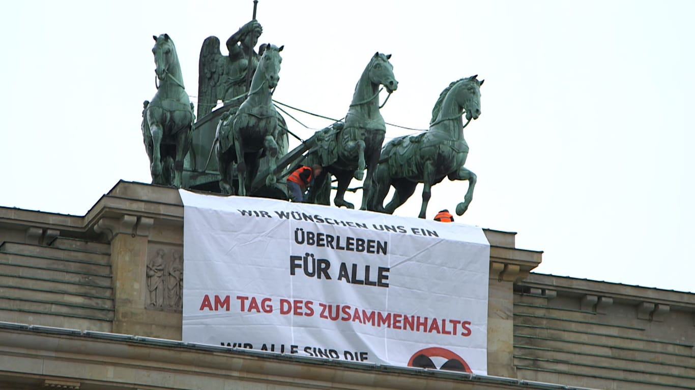 Die Aktivisten auf dem Wahrzeichen: Das Plakat ist nun deutlich sichtbar am Pariser Platz.