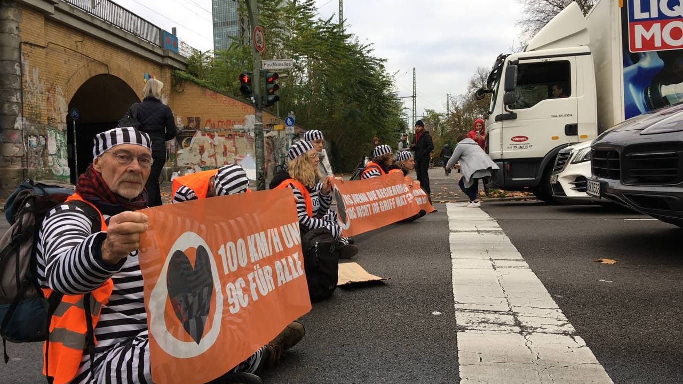 Aktivisten blockieren Berliner Straßen: Für den Protest haben sie sich mit Gefängniskleidung angezogen.