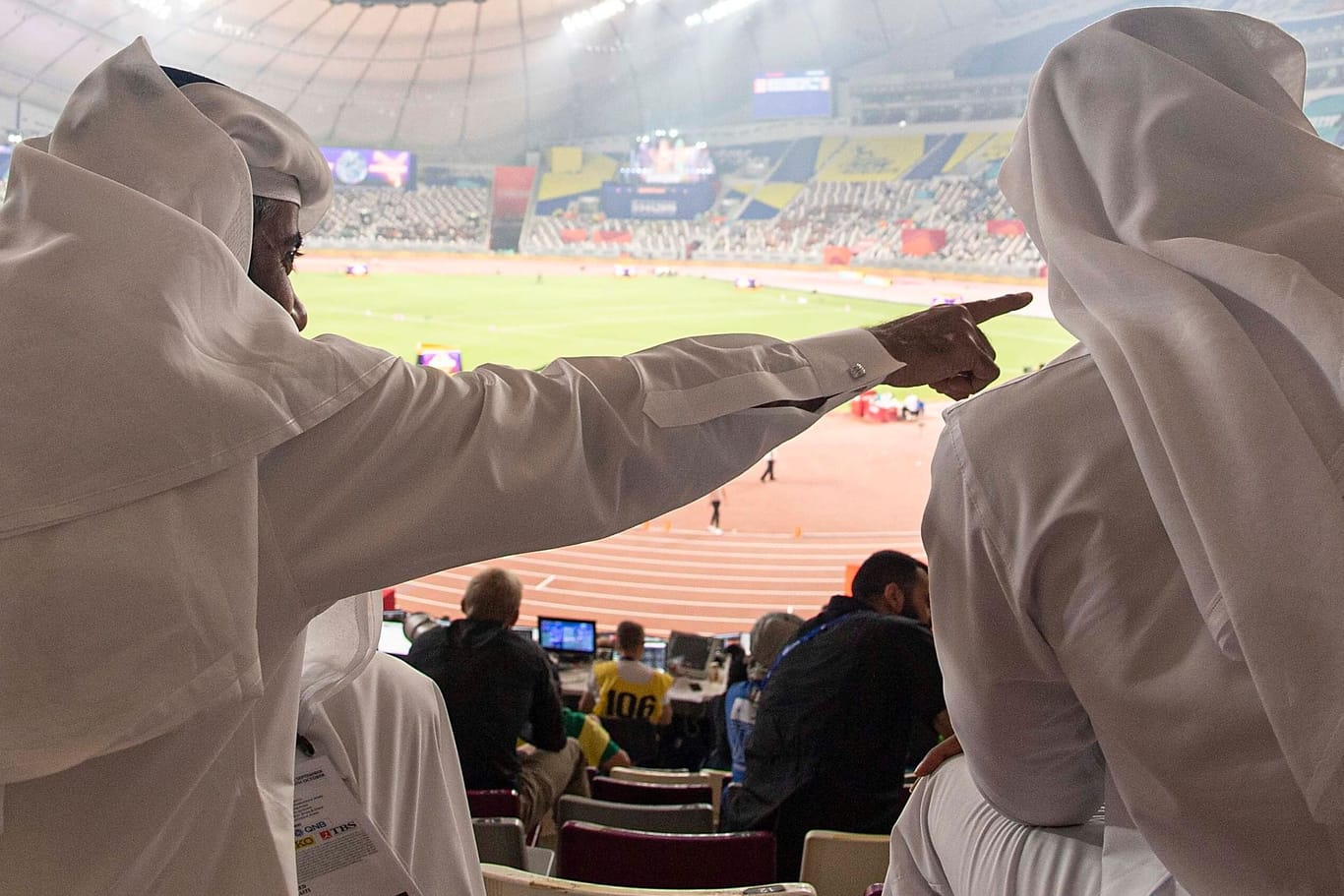 Zwei Männer in traditioneller katarischer Kleidung in einem Stadion.