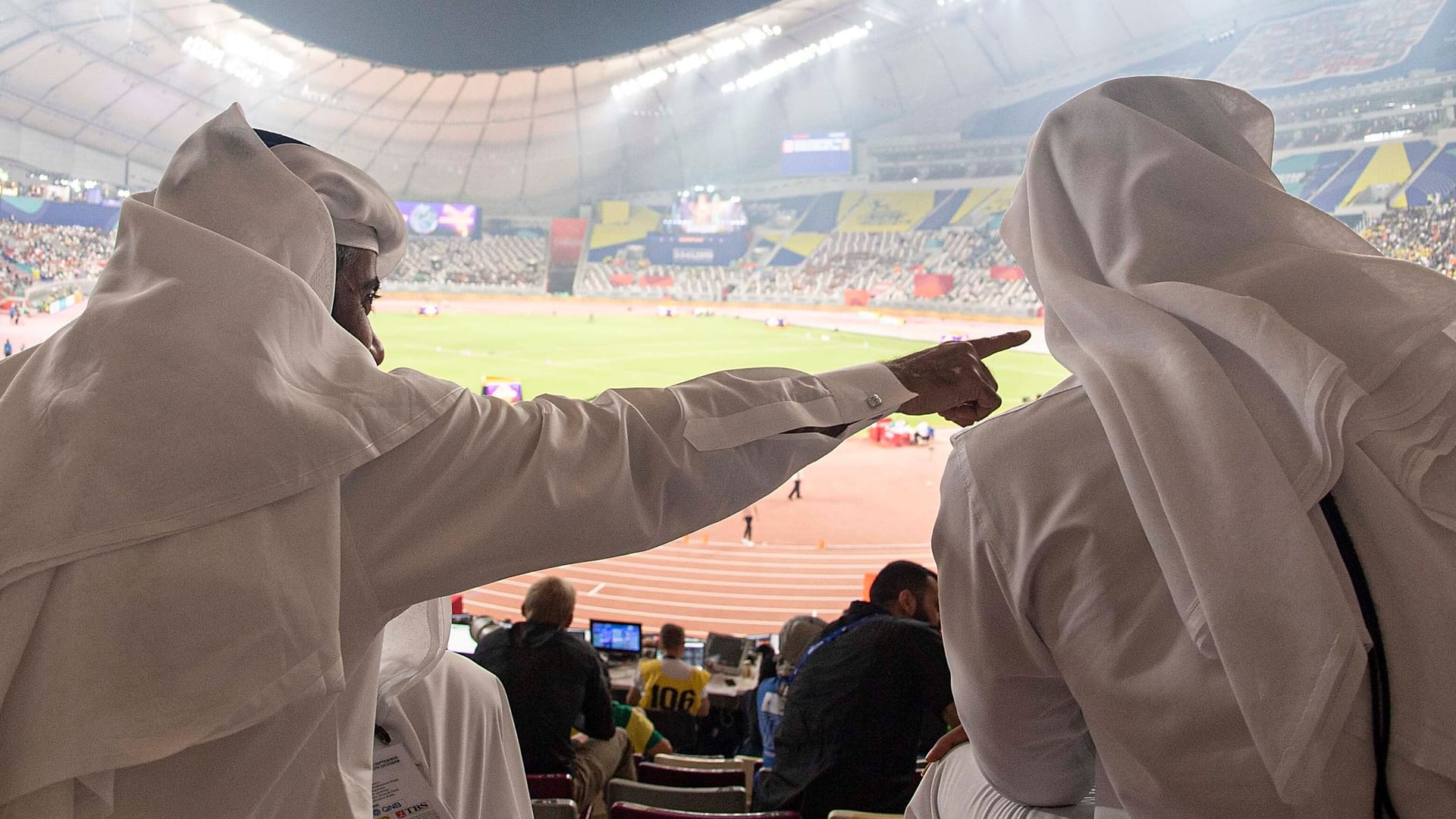 Zwei Männer in traditioneller katarischer Kleidung in einem Stadion. Zwei Männer in traditioneller katarischer Kleidung in einem Stadion.
