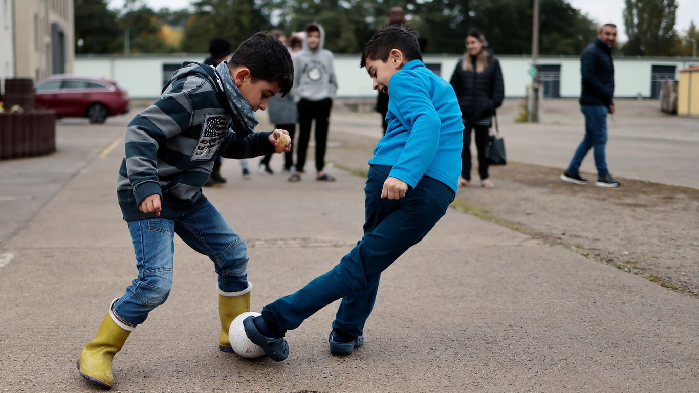 Kinder spielen auf dem Gelände eines Wohnheims für Asylbewerber: Die Bundesregierung will die Antragsfristen für die Einbürgerung verkürzen.