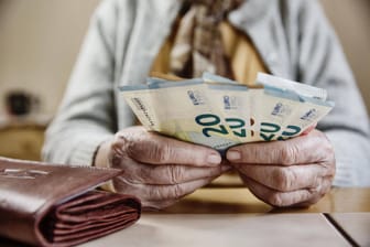 Seniorin hält Euroscheine (Symbolbild): Frauen im Westen erhalten im Schnitt deutlich weniger als 1.000 Euro Rente.