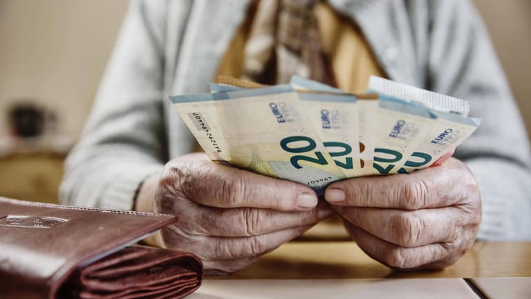 Seniorin hält Euroscheine (Symbolbild): Frauen im Westen erhalten im Schnitt deutlich weniger als 1.000 Euro Rente.