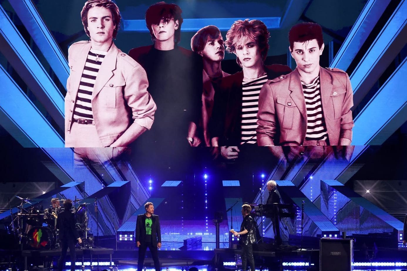 Duran Duran standen bei ihrer Aufnahme in die "Rock and Roll Hall of Fame" ohne Andy Taylor auf der Bühne. Er ist auf einem alten Foto im Hintergrund in der Mitte zu sehen.