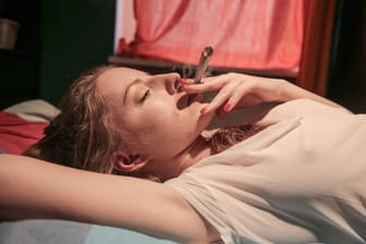 Eine junge Frau raucht einen Joint (Symbolbild): Niedersachsens Justizministerin ist wegen des hohen THC-Gehalts bei Cannabis skeptisch, was eine Legalisierung angeht.