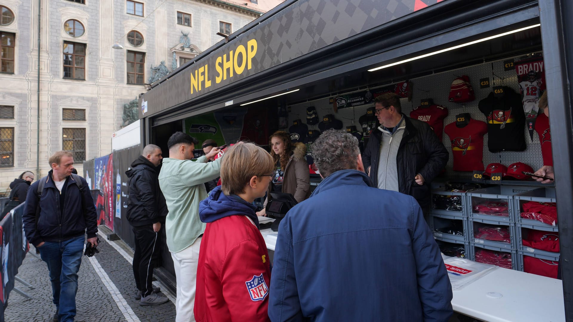 NFL-Fans stehen an einem Verkaufsstand für Football-Kleidung: München ist im Football-Fieber. NFL-Fans stehen an einem Verkaufsstand für Football-Kleidung: München ist im Football-Fieber.