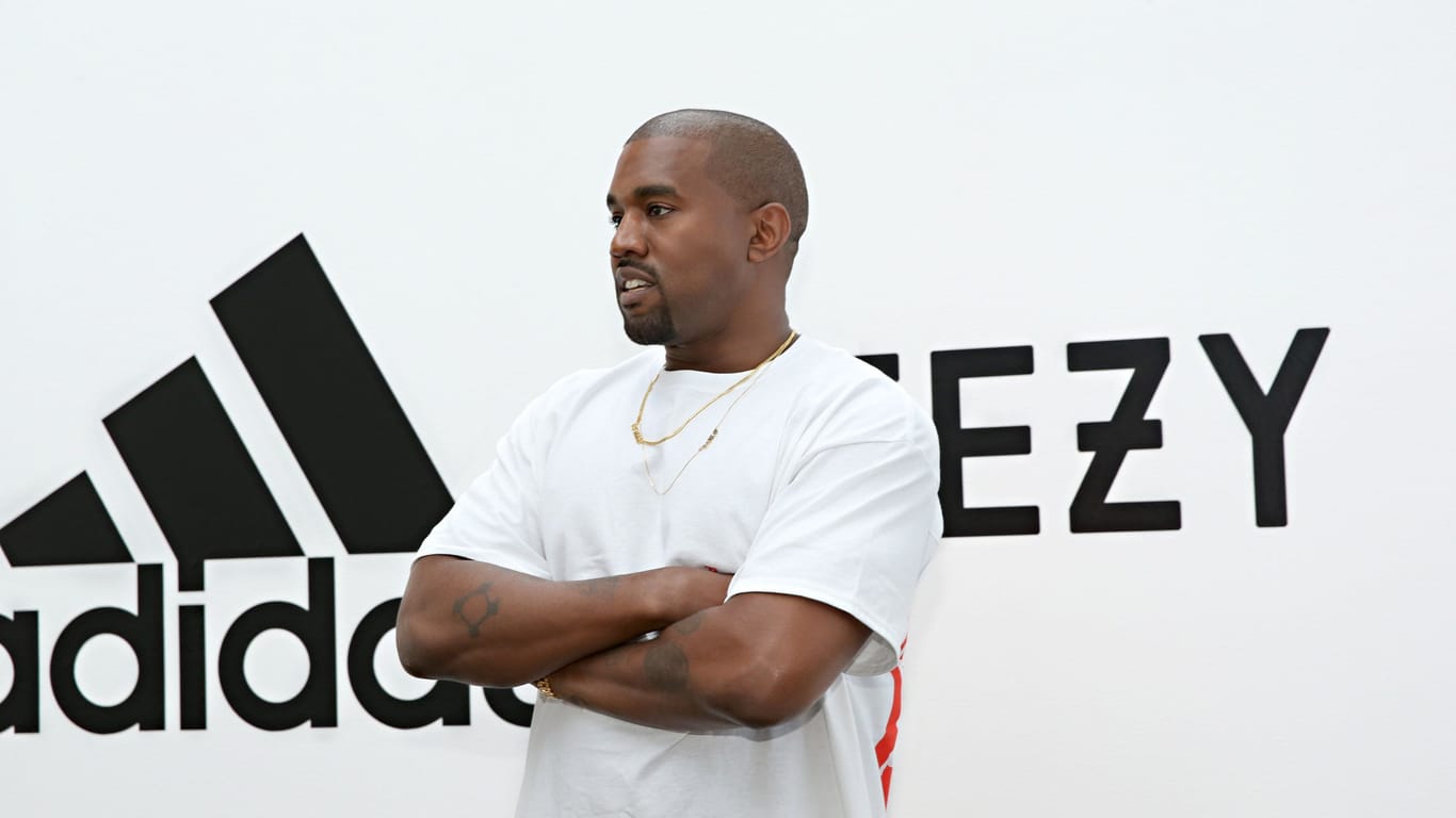 Kanye West mit Adidas-Logo im Hintergrund: Das Unternehmen hat die Partnerschaft mit Kanye West unter anderem wegen antisemitischer Äußerungen des US-Rappers beendet.