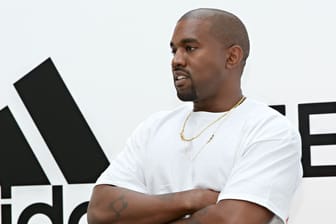 Kanye West mit Adidas-Logo im Hintergrund: Das Unternehmen hat die Partnerschaft mit Kanye West unter anderem wegen antisemitischer Äußerungen des US-Rappers beendet.