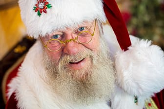 Weihnachtsmann Willi Dahmen sitzt vor einer Fototapete (Archivbild): Vor der Adventszeit hat Dahmen im Internet sein Glück gefunden.