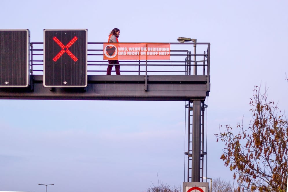 Klimaaktivistin auf einer Schilderbrücke über der Autobahn (Archivbild): Die Polizei hat die Avus gesperrt.