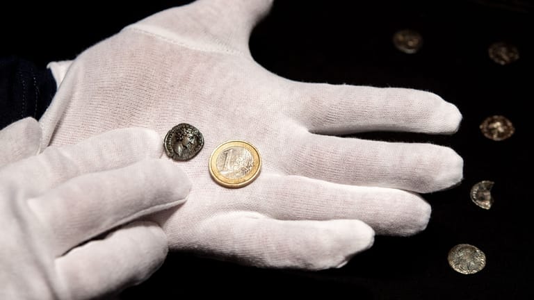 Eine römische Münze und eine Ein-Euro-Münze im Größenvergleich: Insgesamt wurden 96 Silberstücke gefunden.