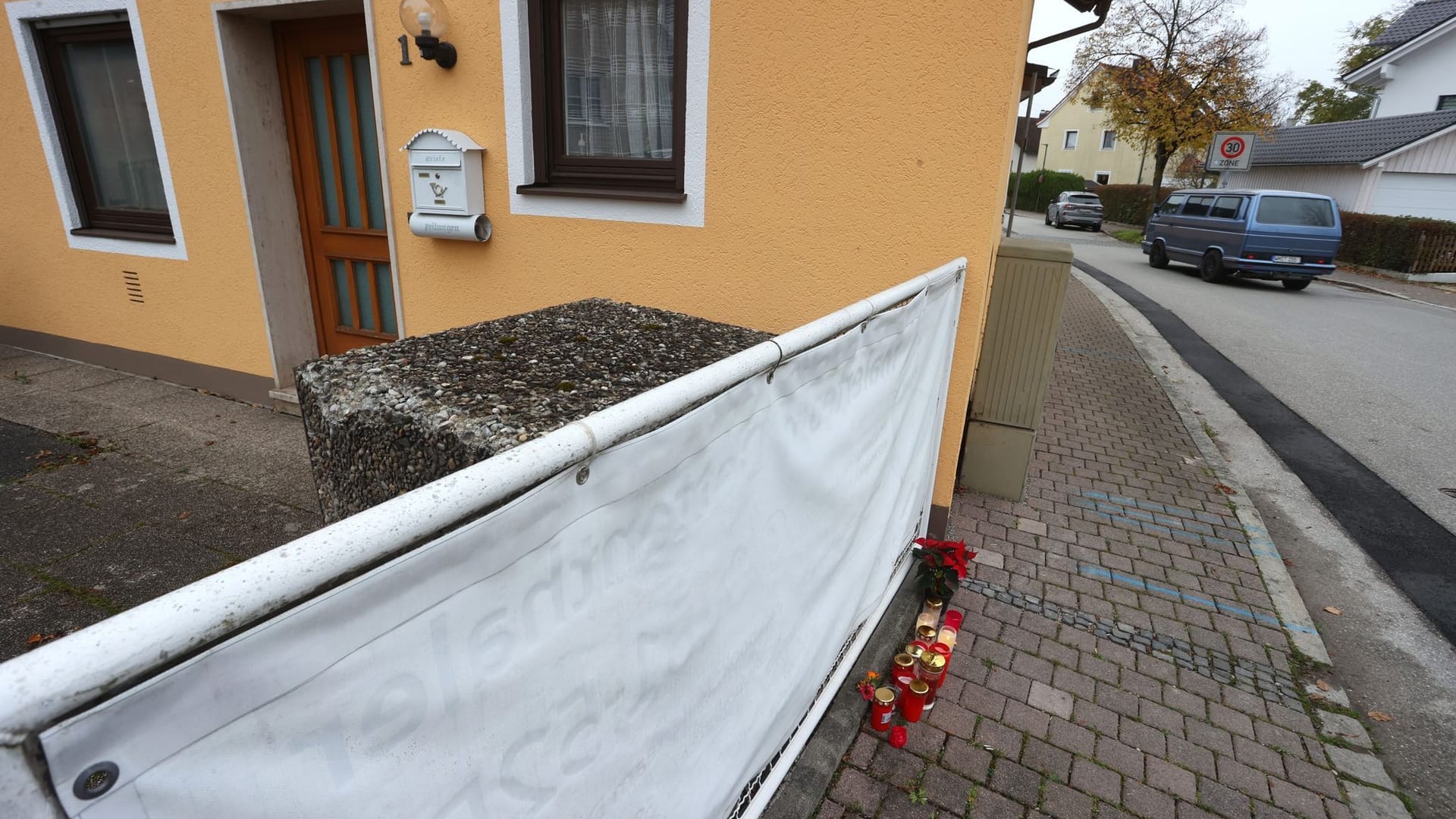 Kerzen und Blumen stehen vor dem Haus in Weilheim, in dem die getöteten Schwestern entdeckt wurden: Das Ergebnis der Obduktion liegt inzwischen vor