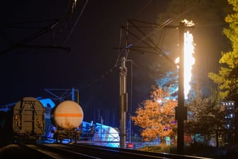 Beschädigte Waggons auf dem Bahndamm, während Gas aus einem Waggon abgebrannt wird (Archivbild): Vorerst geht es mit dem Abpumpen an der Bahnstrecke nicht weiter.