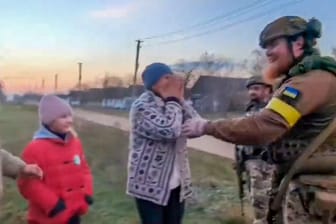 Bewohner eines Dorfes in der Ukraine begrüssen Soldaten.