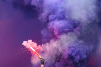 Ein Fan zündet Pyrotechnik während eines Fußballspiels (Symbolfoto): Der Schiedsrichter brach das Spiel umgehen ab.