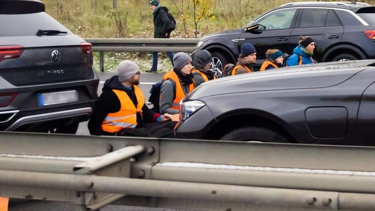 Klima-Klebeaktion auf der A113 am vergangenen Freitag: Die "Letzte Generation" blockierte die Autobahn kurz vor der Ausfahrt zum Flughafen BER.