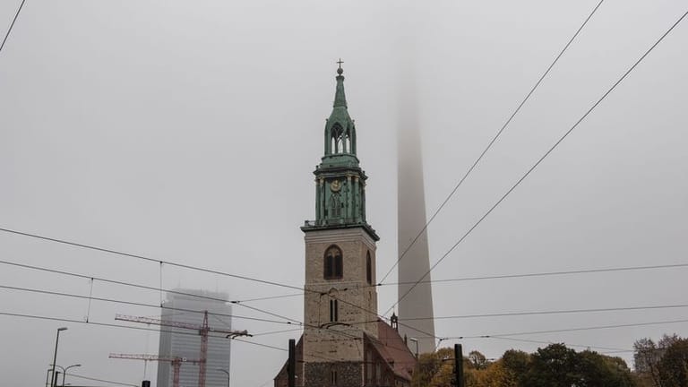 Dichter Nebel hat den Fernsehturm hinter der St. Marienkirche eingehüllt.