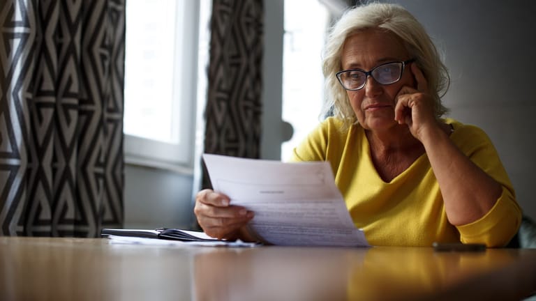Rentnerin sichtet Dokumente (Symbolbild): Wer nur teilweise erwerbsgemindert ist, kann noch Rentenpunkte hinzuverdienen.