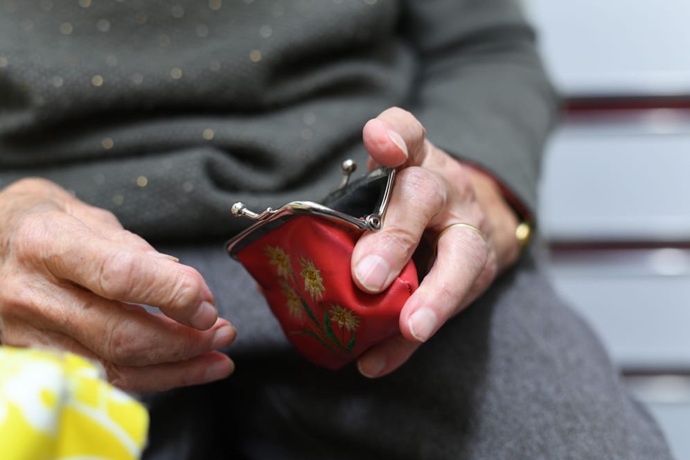Eine Rentnerin hält ihren geöffneten Geldbeutel (Symbolbild): Die Energiepreispauschale von 300 Euro kommt ab Dezember auch Rentnern zugute.