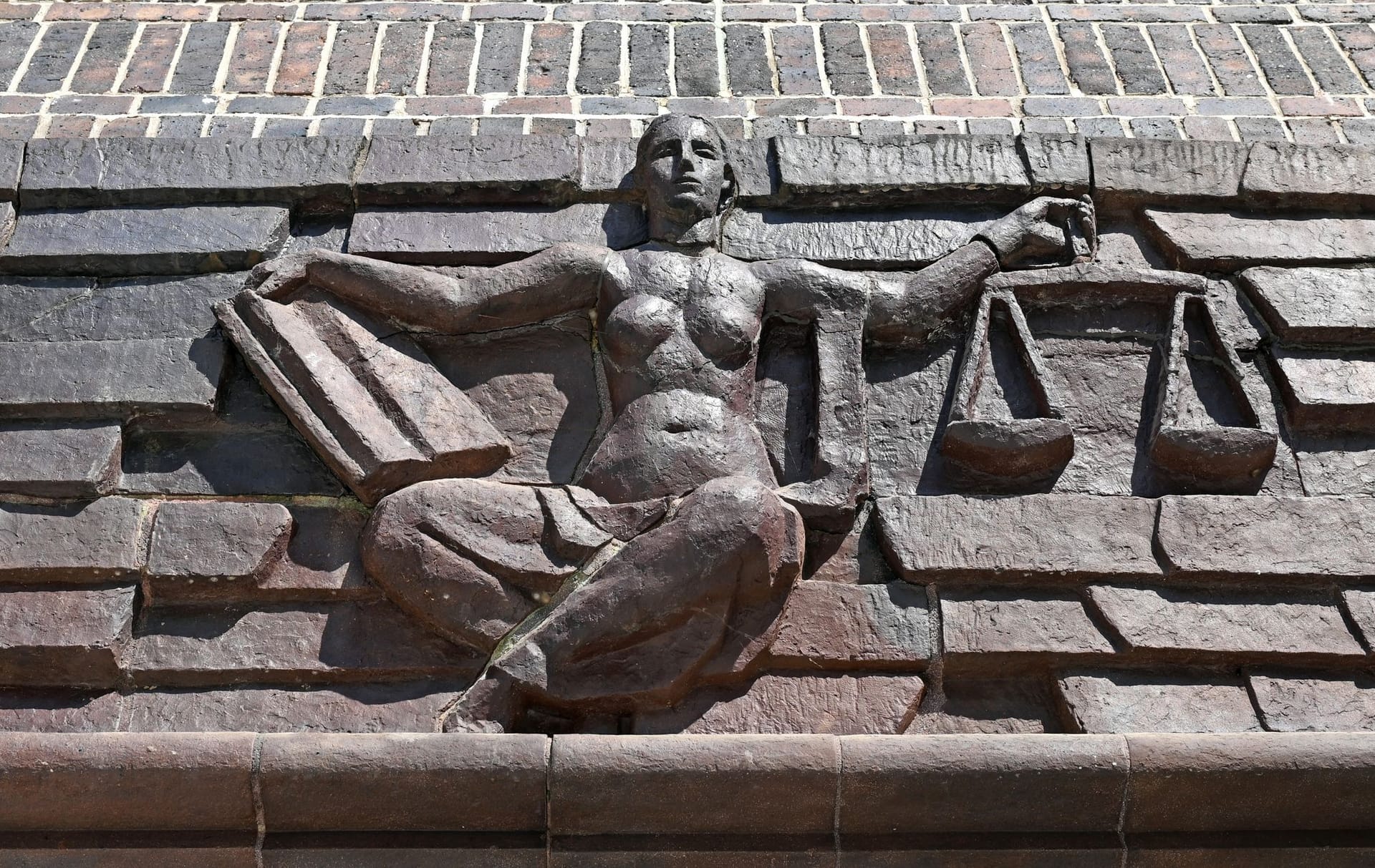 Blick auf die Justitia über dem Eingang eines Landgerichts (Synonym): Das Geld aus dem Drogenhandel wird eingezogen.
