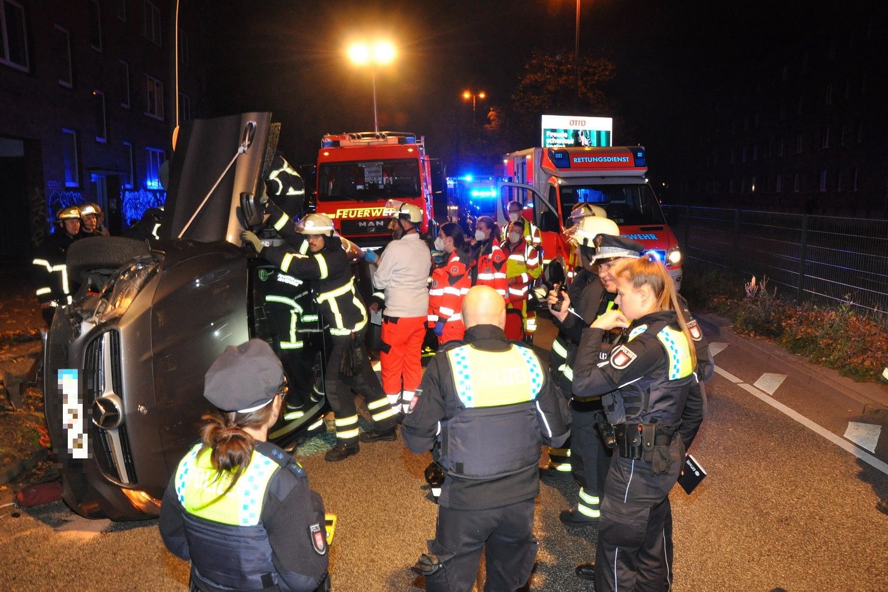 Rettungskräfte stehen neben dem Auto: Eine Insassin soll zunächst nicht ansprechbar gewesen sein.