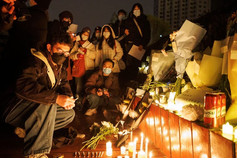 Erinnerung an die Opfer von Ürümqi in Peking: Dass Sicherheitskräfte teilweise selbst Kerzen und Blumen wegräumten, stieß bei den Teilnehmern der Mahnwache auf Unverständnis.