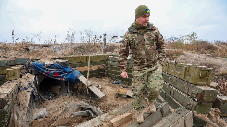 Ein ukrainischer Soldat begutachtet einen ehemaligen russischen Graben in der Oblast Cherson.