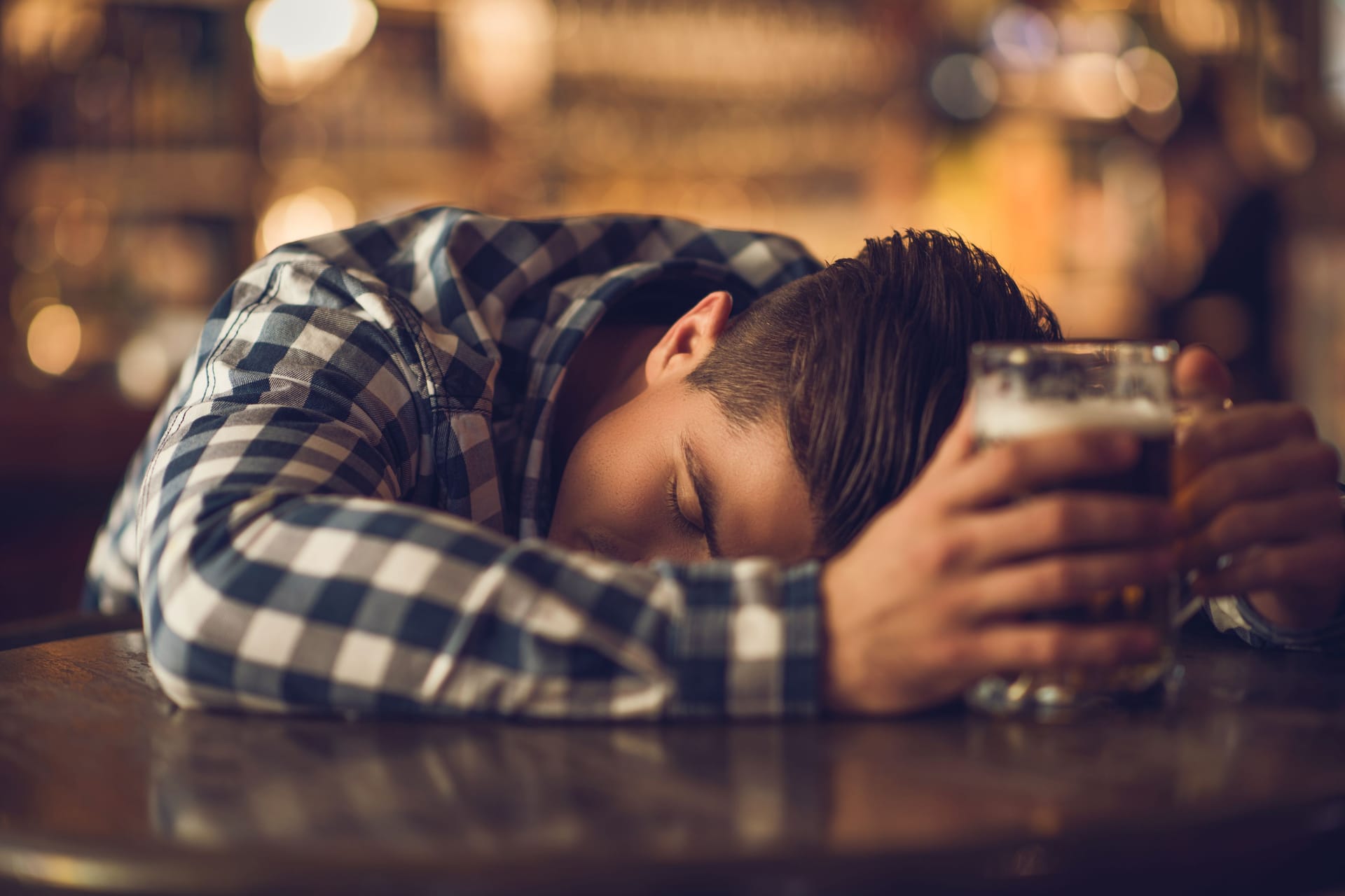 Ein betrunkener Mann schläft in einer Bar.