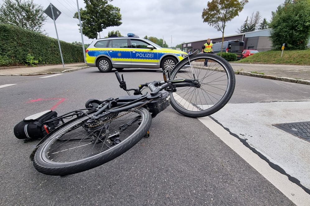 Fahrrad mit Polizeiwagen im Hintergrund (Symbolbild): Eine Verkehrskontrolle wollte die betrunkene Radfahrerin sich nicht gefallen lassen.