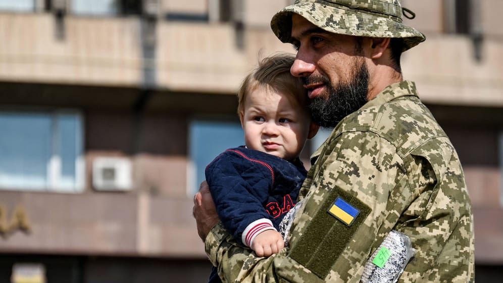 Ein ukrainischer Soldat mit einem Baby: Millionen von Kindern sind von Kriegen und Konflikten bedroht.