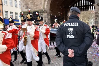Ein Polizist beim Karneval (Archivbild): Ein Häftling brach aus und floh nach Köln, um zu feiern.