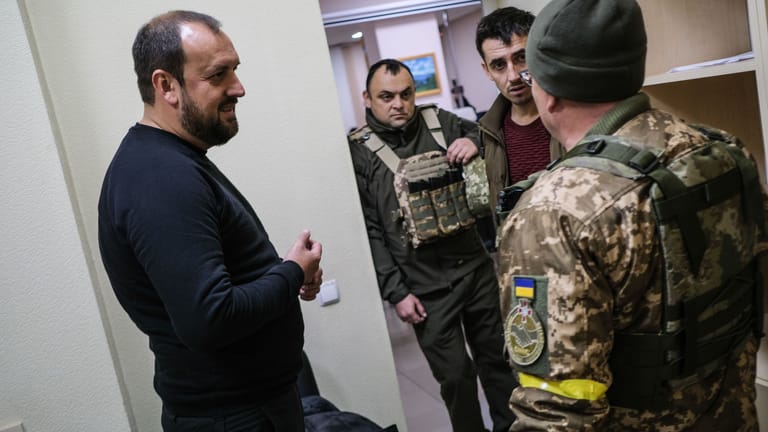 Andriy Besedin, the acting mayor of Kupiansk, left, talks with troops at a temporary government building in Kupiansk on November 12, 2022. Credit: Byron Smith