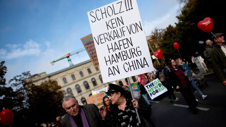 Aktivisten mit Plakat: Bei der Demonstration der sozialen Bewegung Solidarischer Herbst wurde Kanzler Olaf Scholz für den Hamburger Hafendeal stark kritisiert.