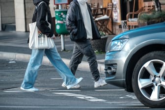 Ein abbiegender SUV-Fahrer lässt Fußgänger auf einer Düsseldorfer Straßenkreuzung passieren: Hier blieben die Wagebn verschont, unter anderem in Bonn schlugen die "Tyre Extinguishers" zu.