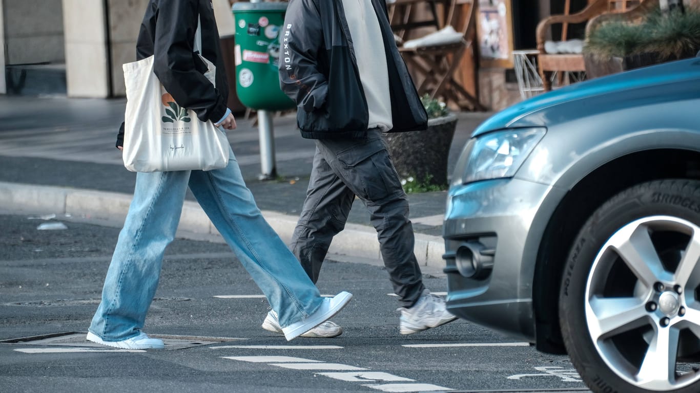 Ein abbiegender SUV-Fahrer lässt Fußgänger auf einer Düsseldorfer Straßenkreuzung passieren: Hier blieben die Wagebn verschont, unter anderem in Bonn schlugen die "Tyre Extinguishers" zu.
