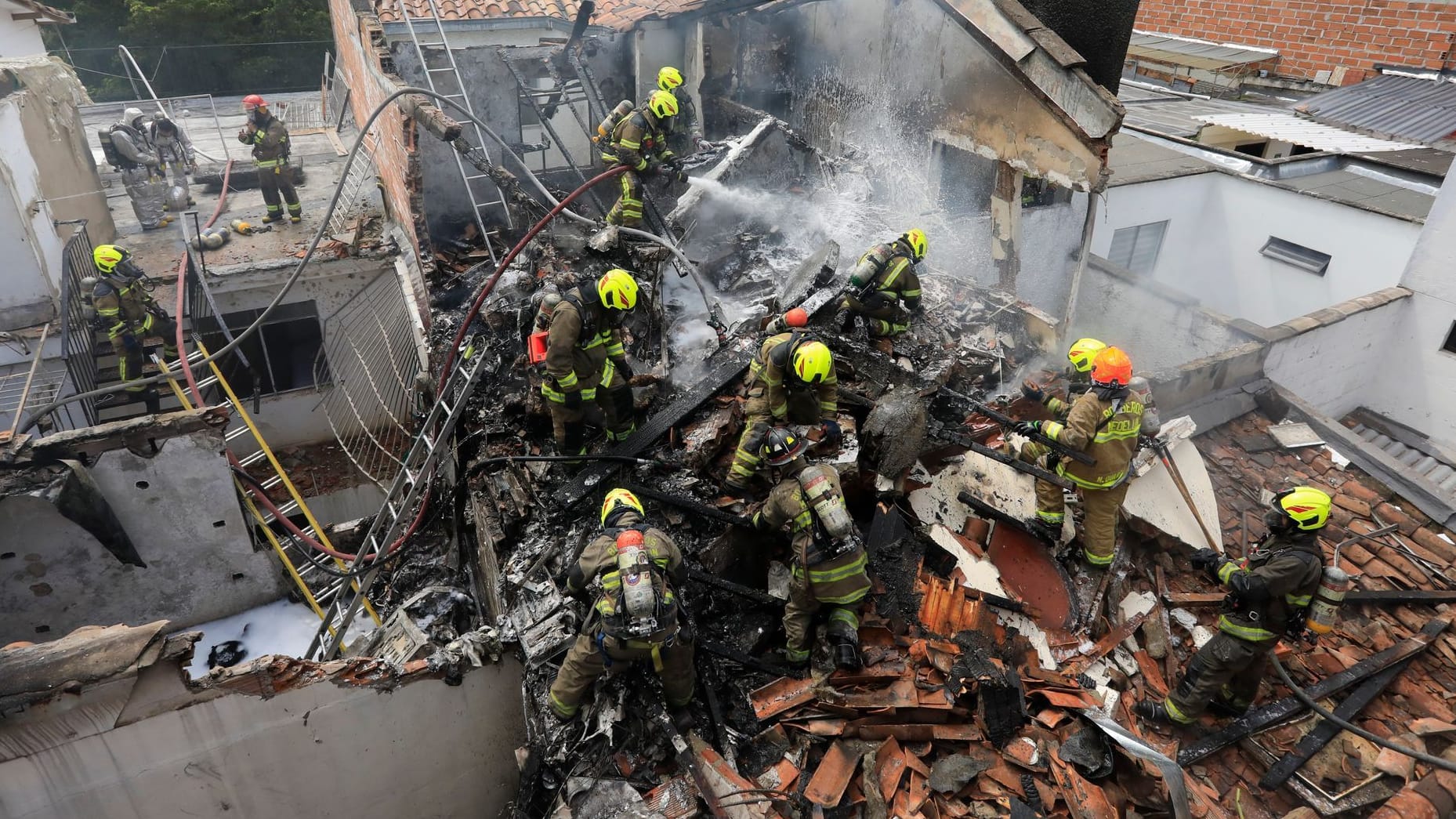 Feuerwehrleute an der Absturzstelle: Mehrere Wohnungen wurden beschädigt. Feuerwehrleute an der Absturzstelle: Mehrere Wohnungen wurden beschädigt.