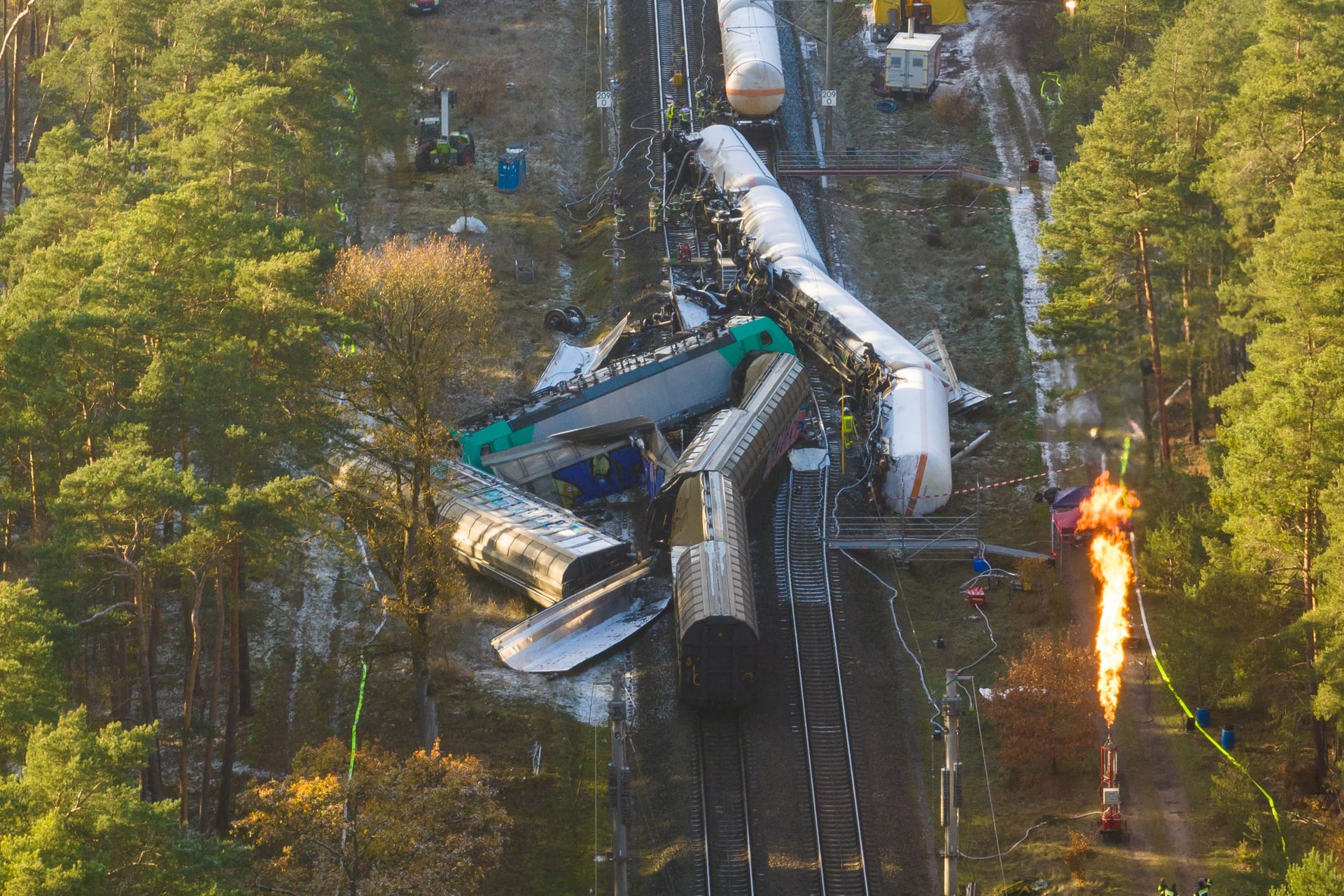 Beschädigte Waggons auf dem Bahndamm, während Gas abgefackelt wird (Archivbild): Pro Bahn kritisiert die Deutsche Bahn aufgrund der Fahrgastinformationen nach der Streckensperrung.